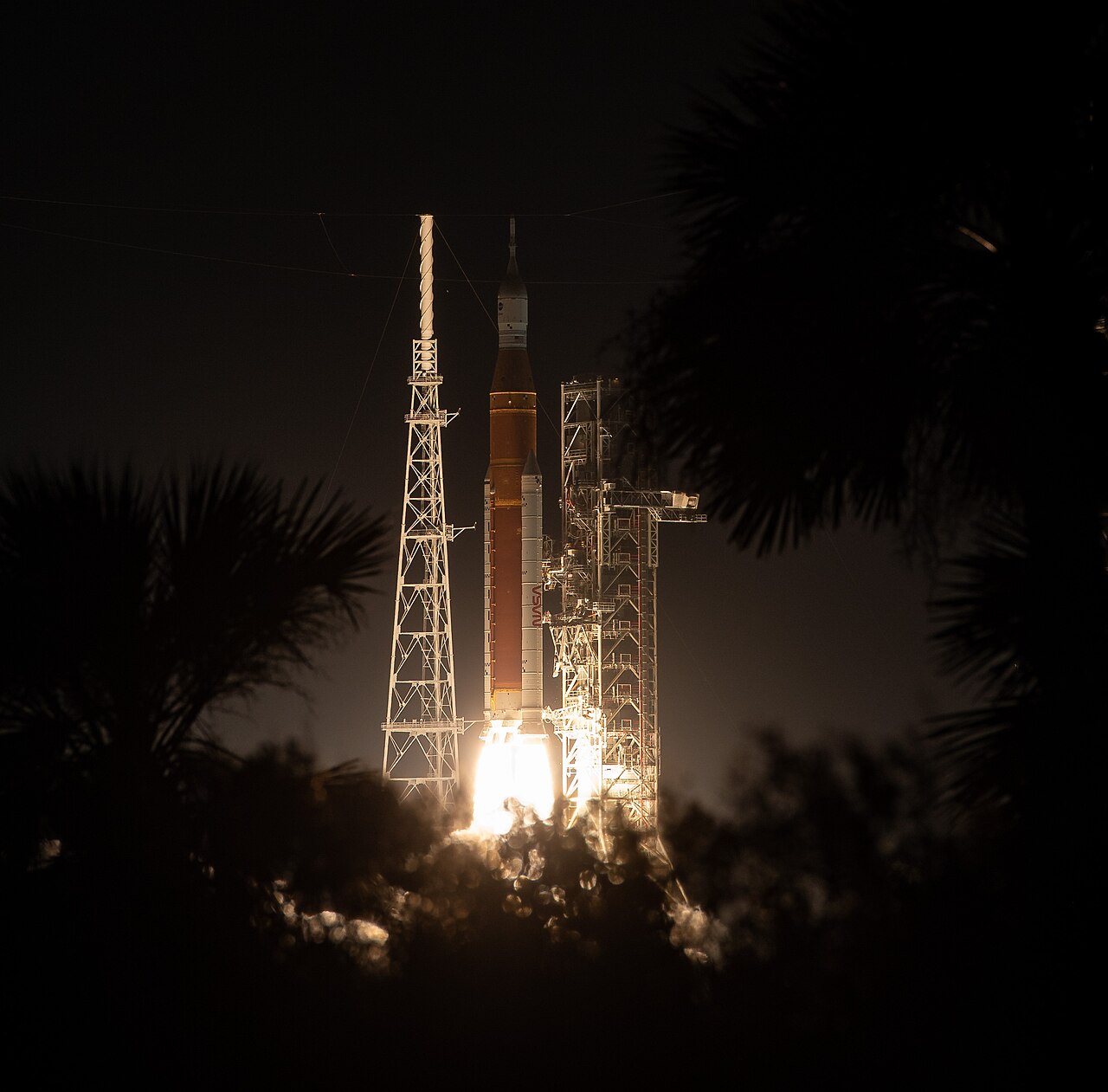 NASA Space Launch System rocket lifting off on the Artemis I mission at night
