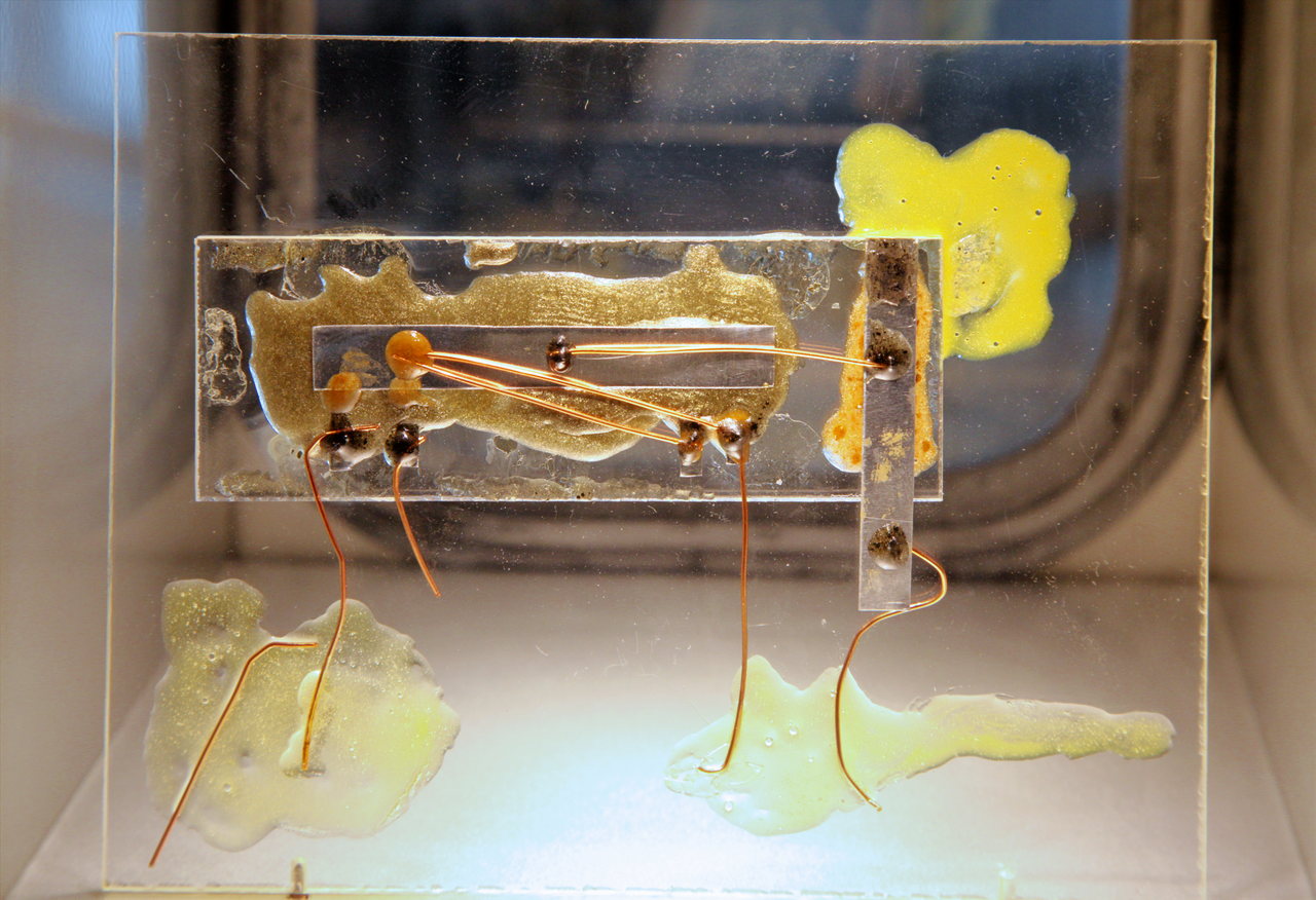 A museum replica of Jack Kilby’s first integrated circuit with a small semiconductor bar and fine connecting wires.