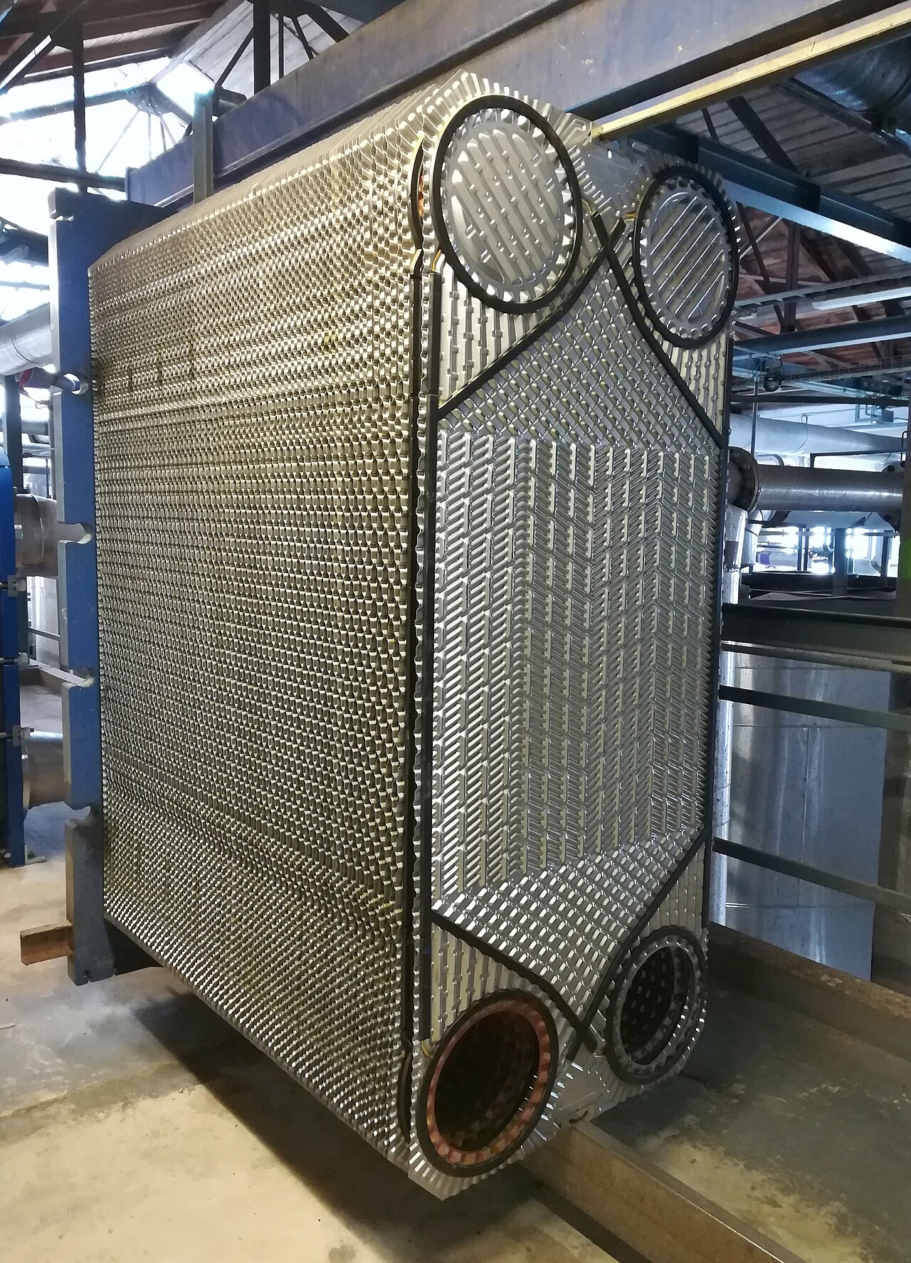 Dismantled plate heat exchanger showing its frame and stacked metal plates