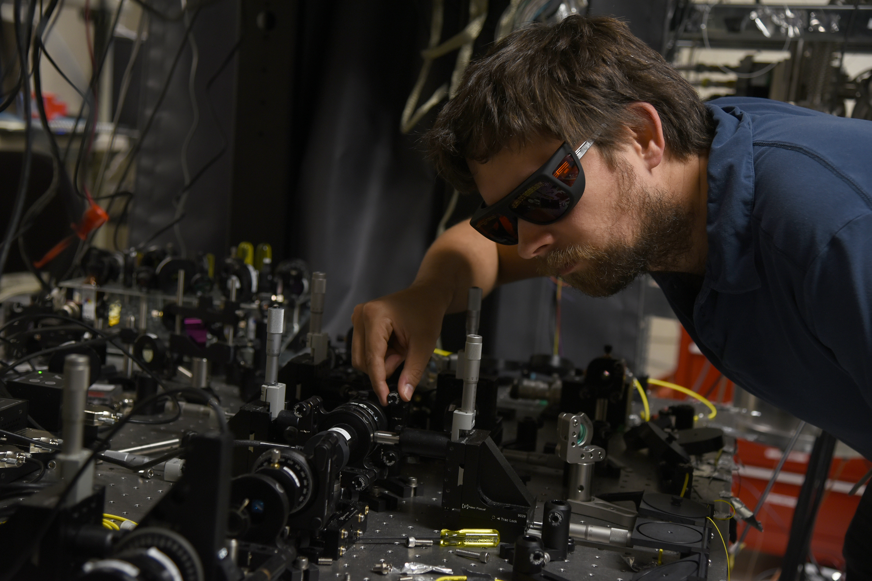 NIST physicist Krister Shalm beside optical equipment used as a photon source for a Bell test.