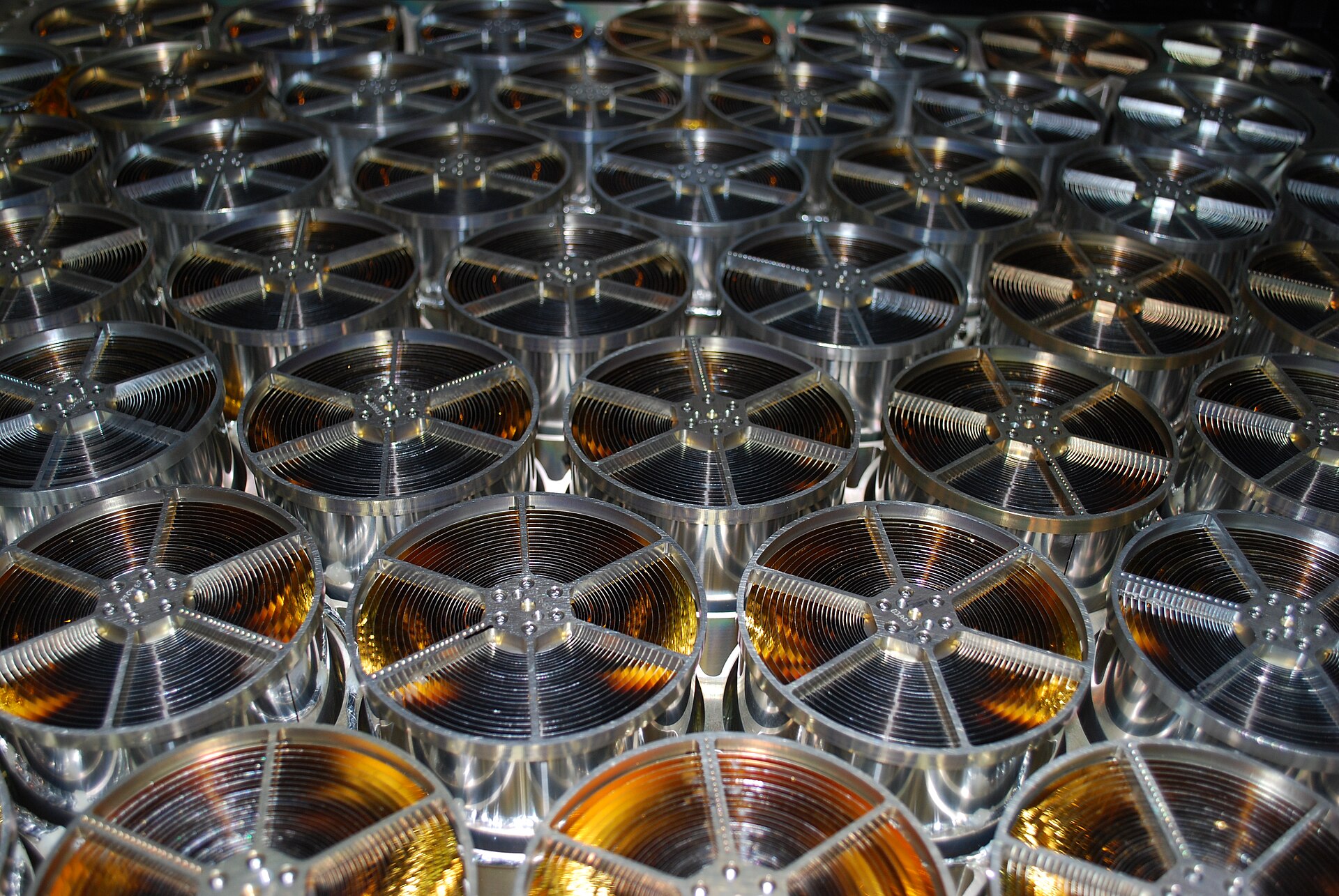 Rows of gold-colored concentric X-ray concentrator mirrors inside the NICER instrument optical bench.
